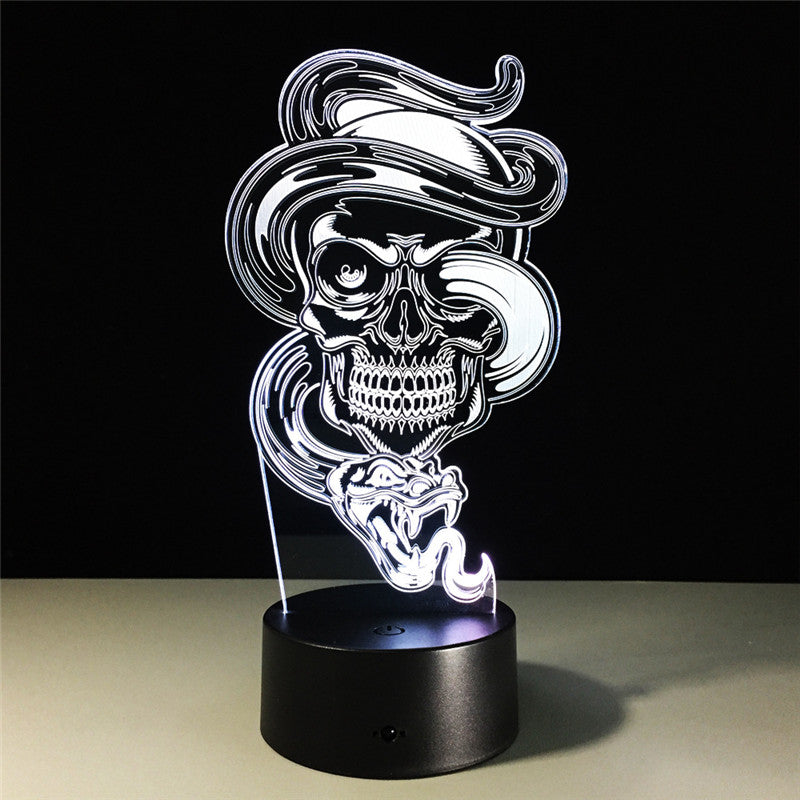 A 3D optical illusion LED night light featuring a stylized skull smoking a cigar, illuminated in white against a black background, resting on a black cylindrical base.